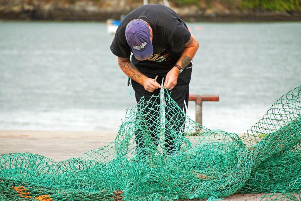 Man working on fishing net, Kinsale, County Cork, Ireland